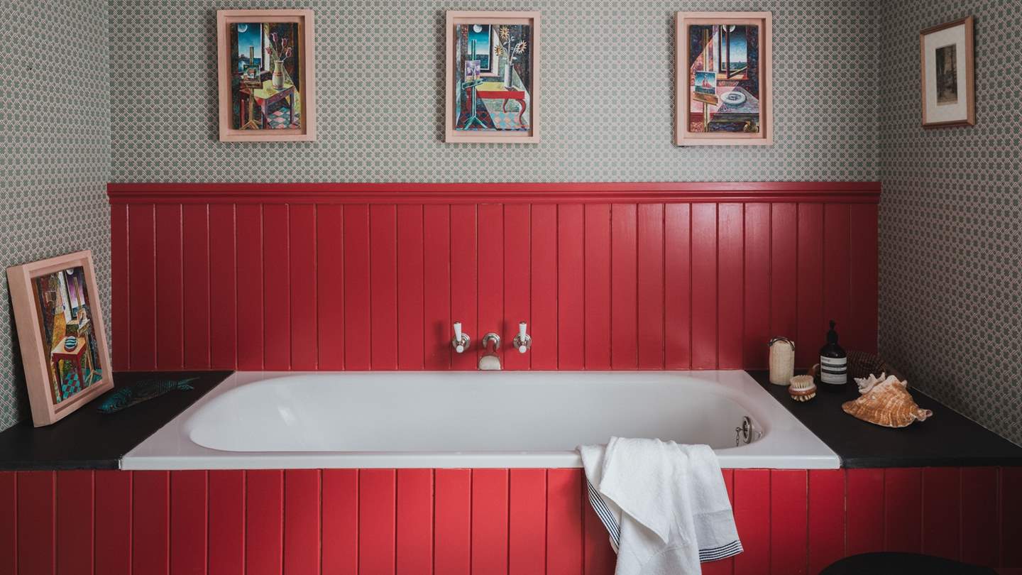Next door is the welcoming family bathroom, with a tongue-and-groove panelled Burlington bathtub painted in Blazer by Farrow and Ball 