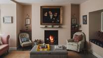 The formal living room draws the eye with antique art and playful fabrics