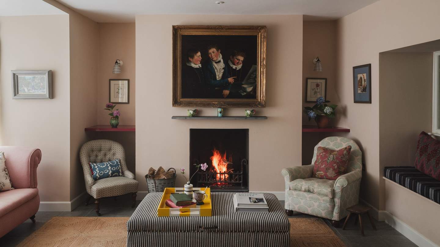 The formal living room draws the eye with antique art and playful fabrics