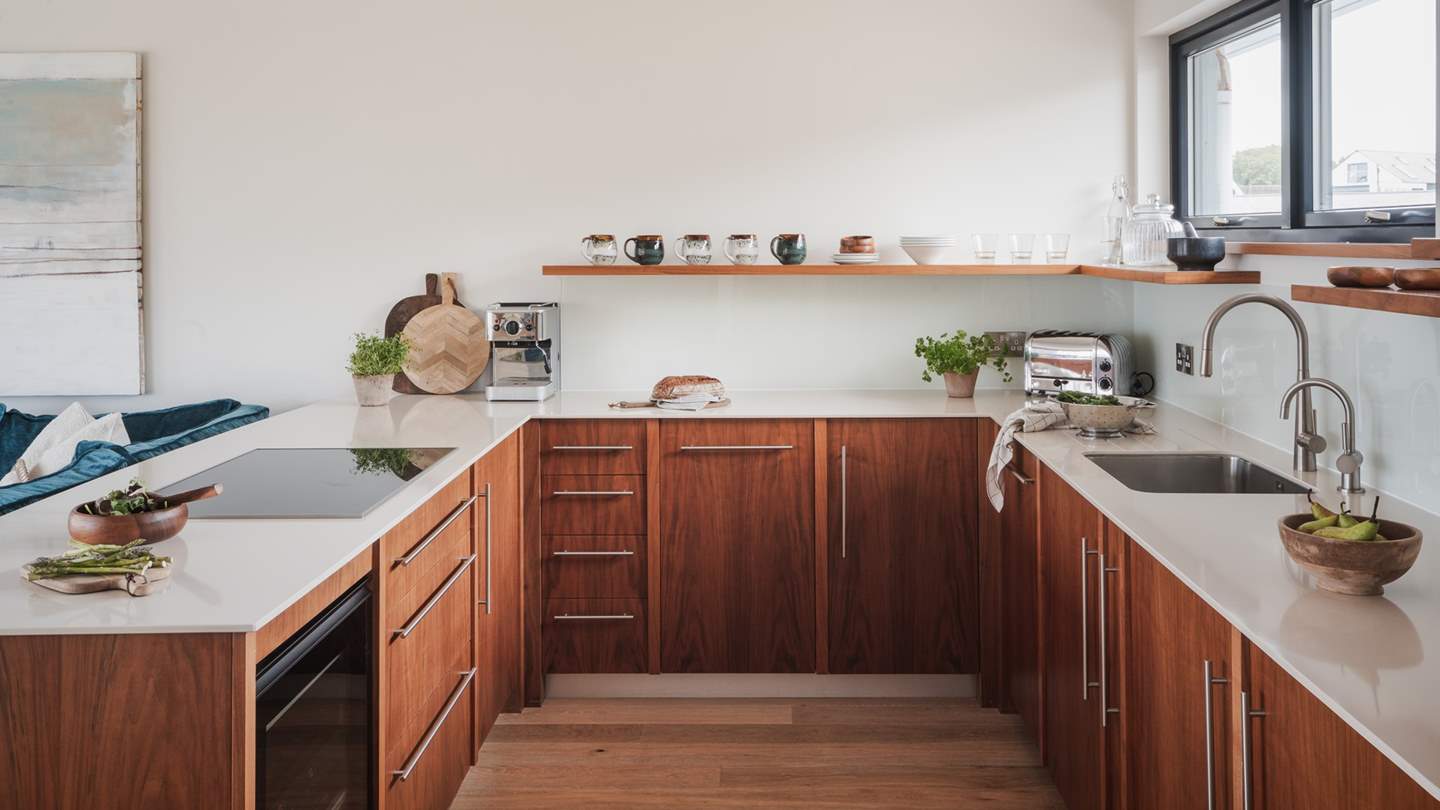 Local walnut wood cabinetry promises an inviting space for the chefs of the party...