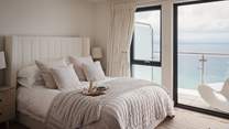 Calming neutrals and spellbinding shoreline vistas set the scene for slumber in the romantic bedroom