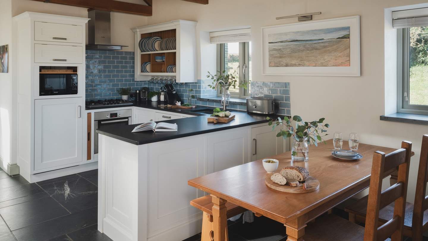 A pretty farmhouse-style dining table and benches sit handily close to the kitchen