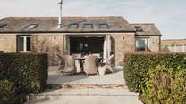 One step leads from the living space onto the patio, there are further steps leading from the patio onto the lawn below

