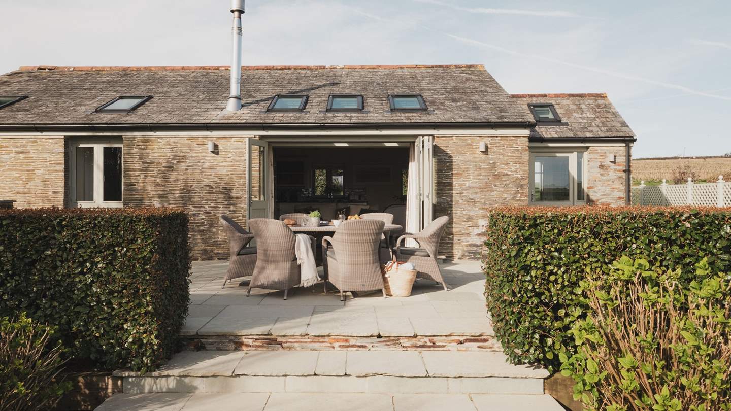 One step leads from the living space onto the patio, there are further steps leading from the patio onto the lawn below

